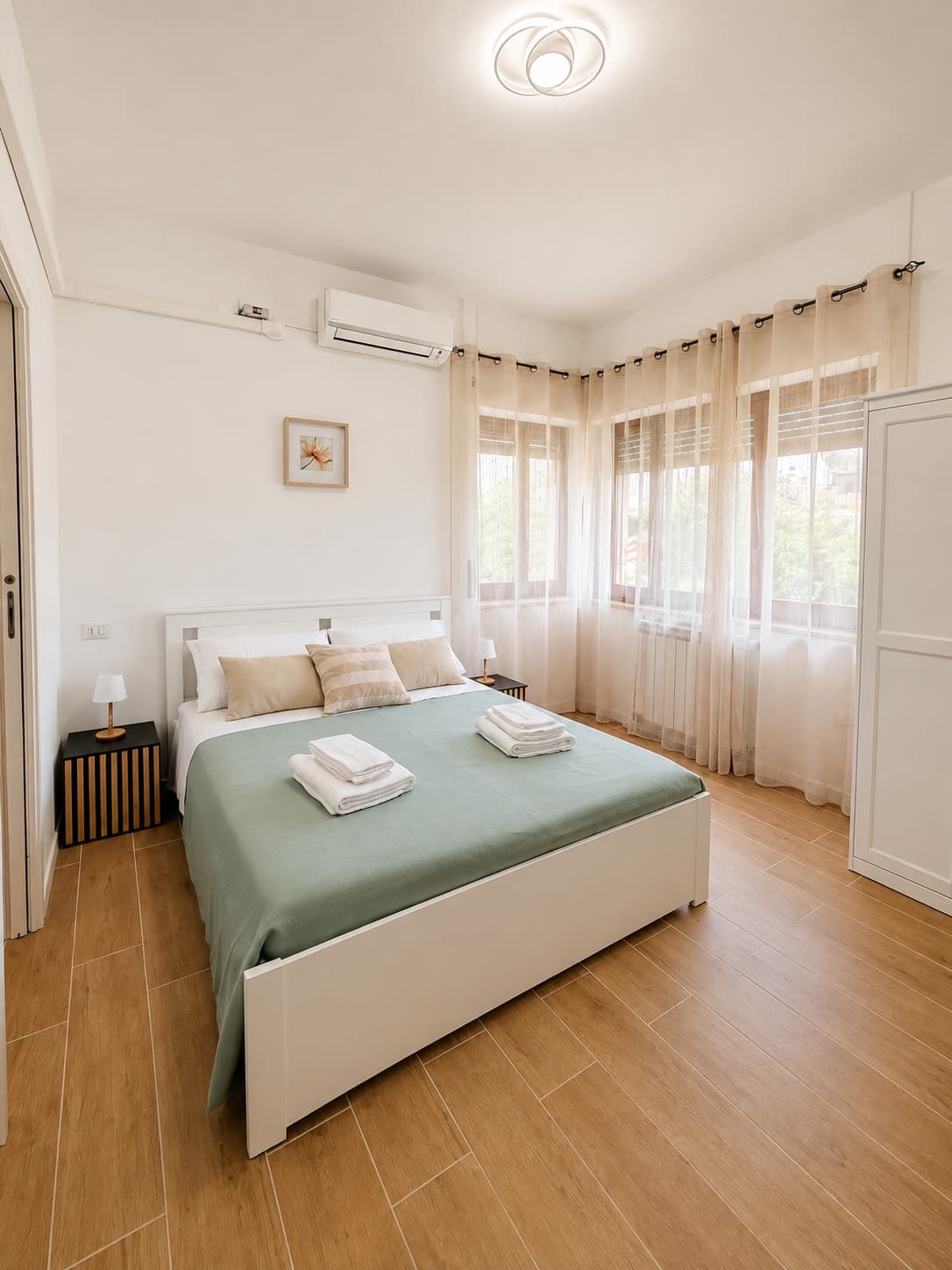 Camera con letto matrimoniale e biancheria verde salvia